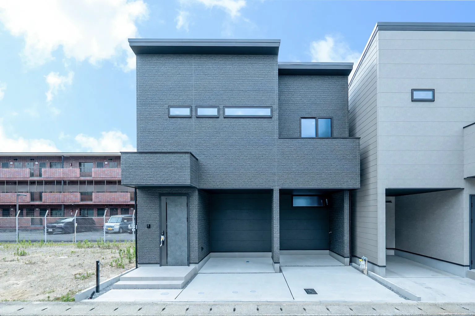京都市中京区の注文住宅 石目調のモノトーン外観とガレージ