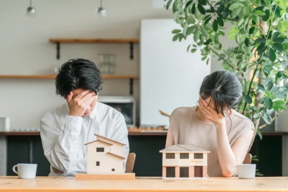 思い悩んで顔に手を当ててうつむいている男女の姿